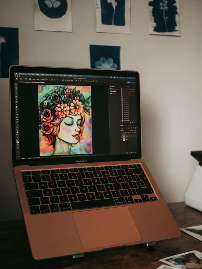 A laptop screen displaying vibrant digital artwork in a home setting.