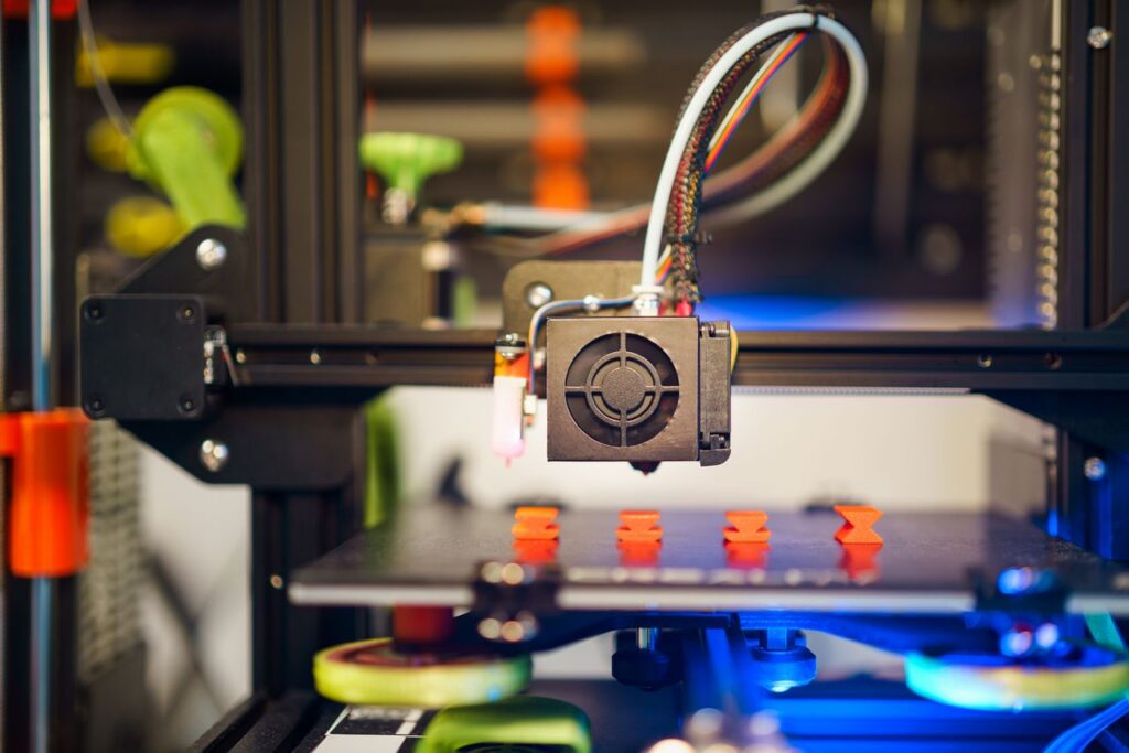 Mastering the First Impression: Your intriguing post title goes here Detailed view of a 3D printer in action, fabricating small plastic pieces indoors.